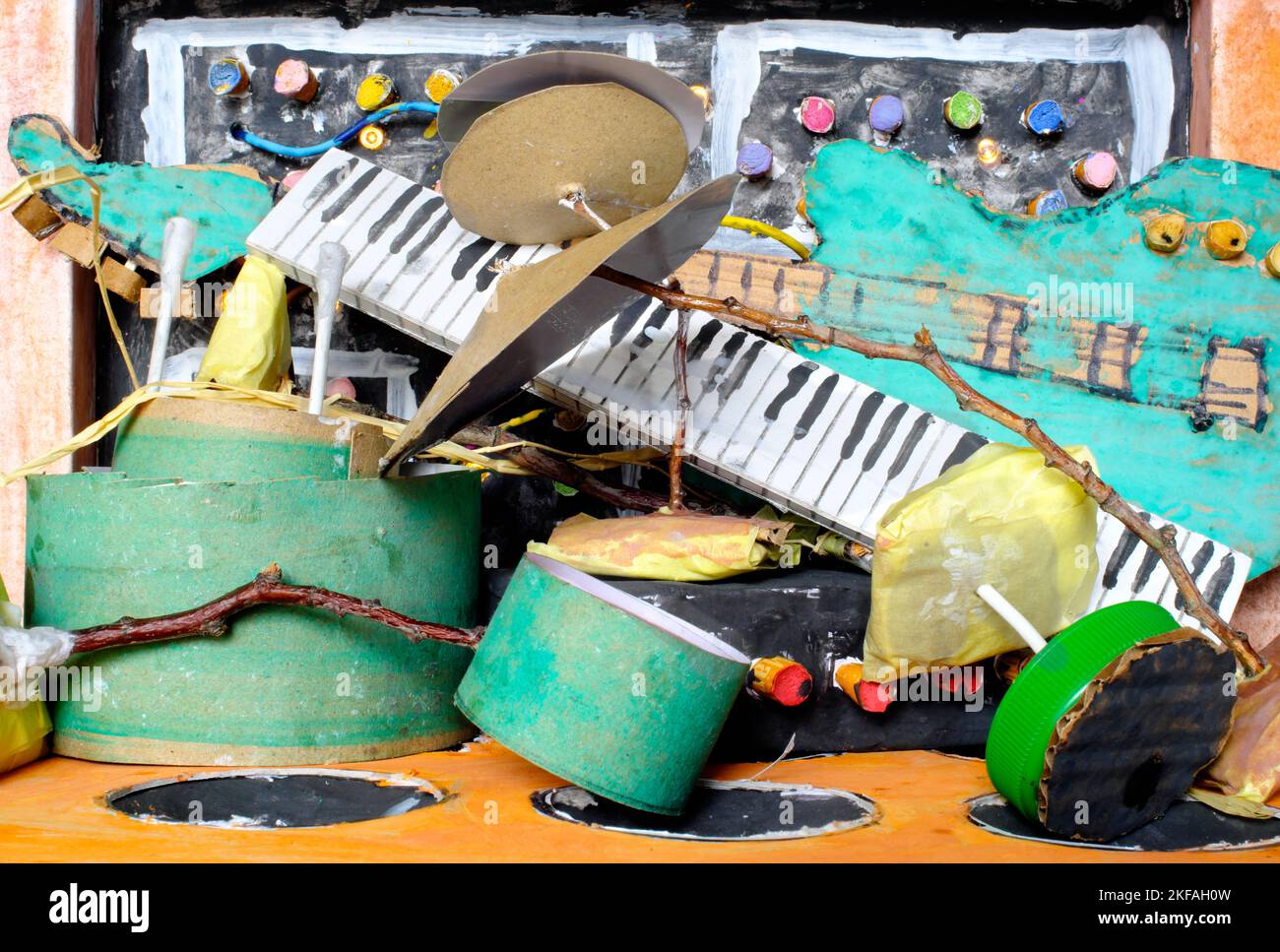 Cumulo disordinato di modelli di cartone rungy di strumenti musicali sintetizzatore,drum kit,chitarra,amplificatore e microfono.Musica,performance,strumenti concetto Foto Stock