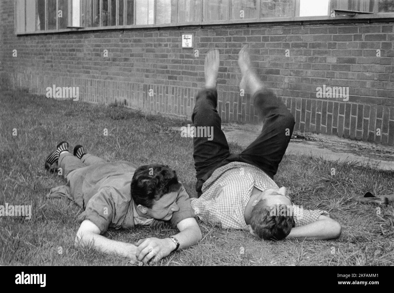 Arbeiter liegend auf dem Rasen während einer Pause am VW Werk in Wolfsburg, Deutschland 1962. Lavoratori che si trovano sull'erba durante una pausa nello stabilimento VW di Wolfsburg, Germania 1962. Foto Stock