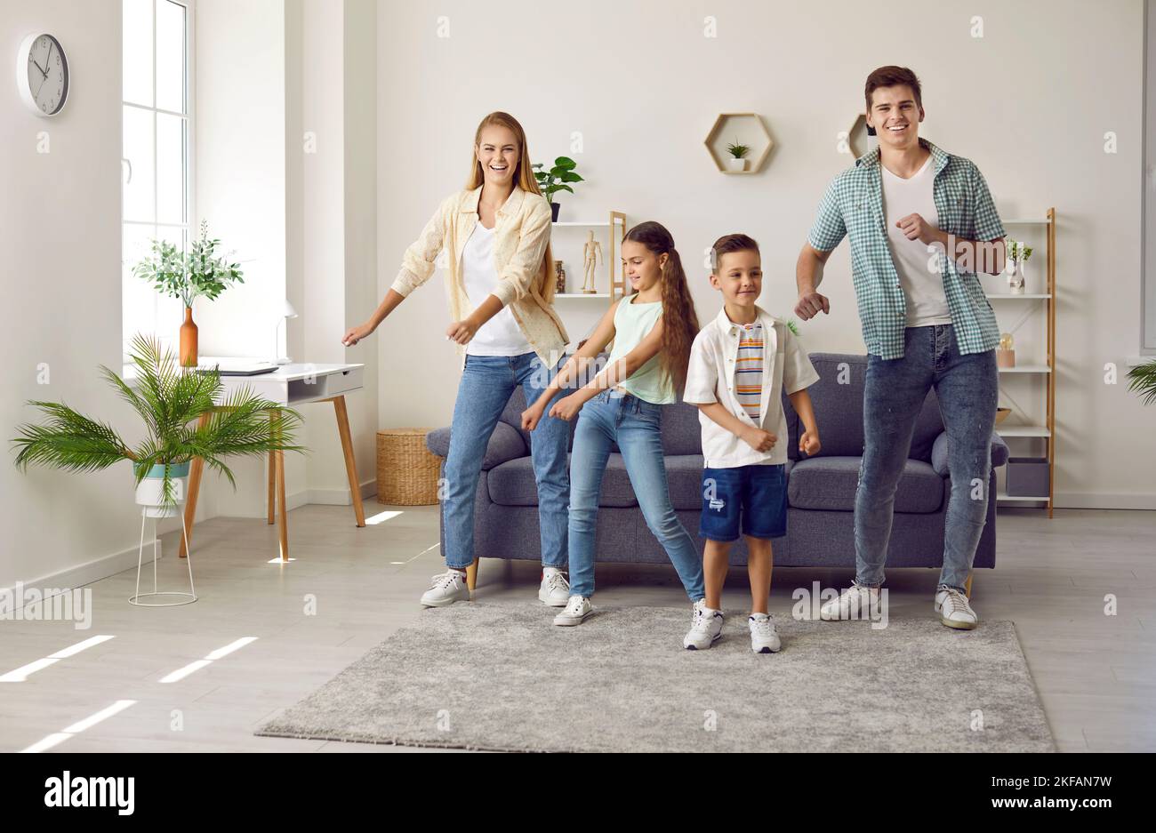 Famiglia felice che si diverte insieme a piccolo figlio e figlia in un soggiorno moderno. Foto Stock