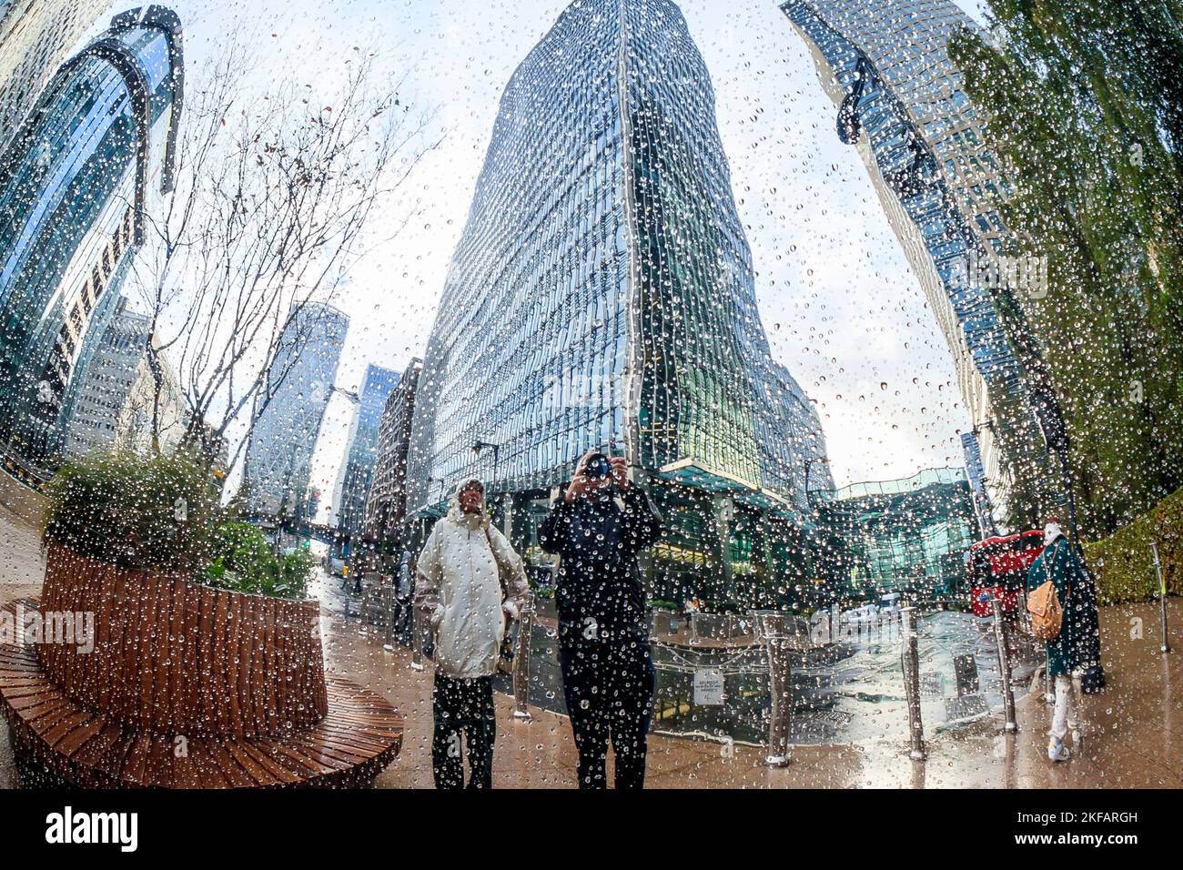 Riflessi di alti edifici nella superficie lucida spruzzata dalla pioggia di un'opera d'arte pubblica al Canary Wharf, Londra, Regno Unito Foto Stock