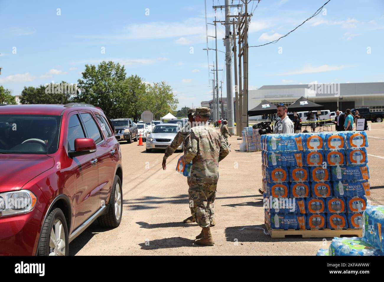 Un soldato della guardia nazionale del Mississippi porta l'acqua all'auto di una persona presso la zona fieristica dello stato del Mississippi a Jackson, Mississippi, 1 settembre 2022. Quasi 600 membri della guardia nazionale del Mississippi sono stati allestiti in sette siti attraverso Jackson per consentire alle persone di raccogliere acqua in bottiglia e acqua non potabile dai camion dei bufali d'acqua. (STATI UNITI Foto della Guardia Nazionale dell'esercito da parte del personale Sgt. Connie Jones) Foto Stock