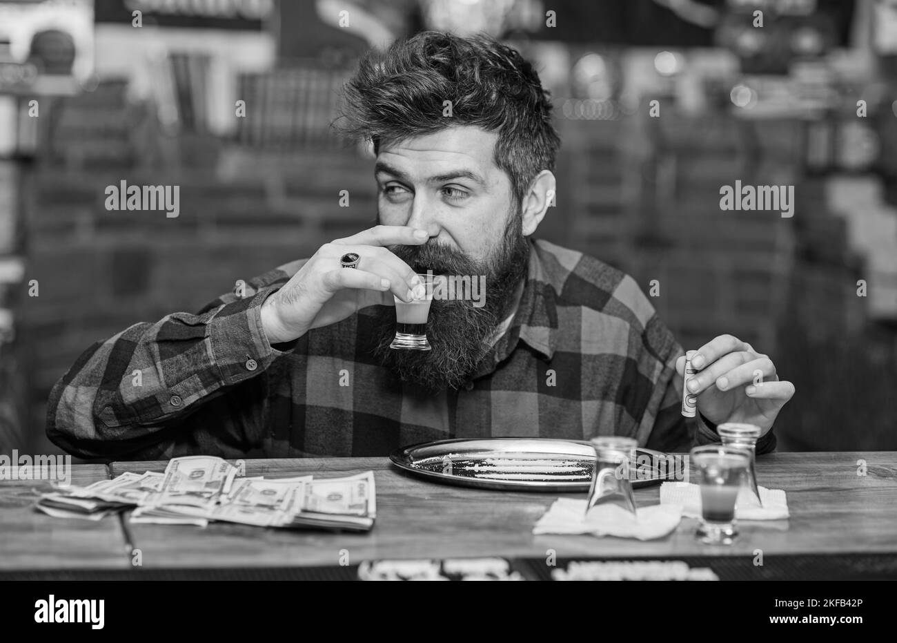 L'uomo con il viso allegro ubriaco siede da solo al bancone del bar. Foto Stock