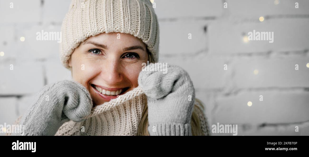 donna sorridente in caldo abbigliamento invernale. maglione di lana, cappello e guanti da taglio. spazio copia Foto Stock