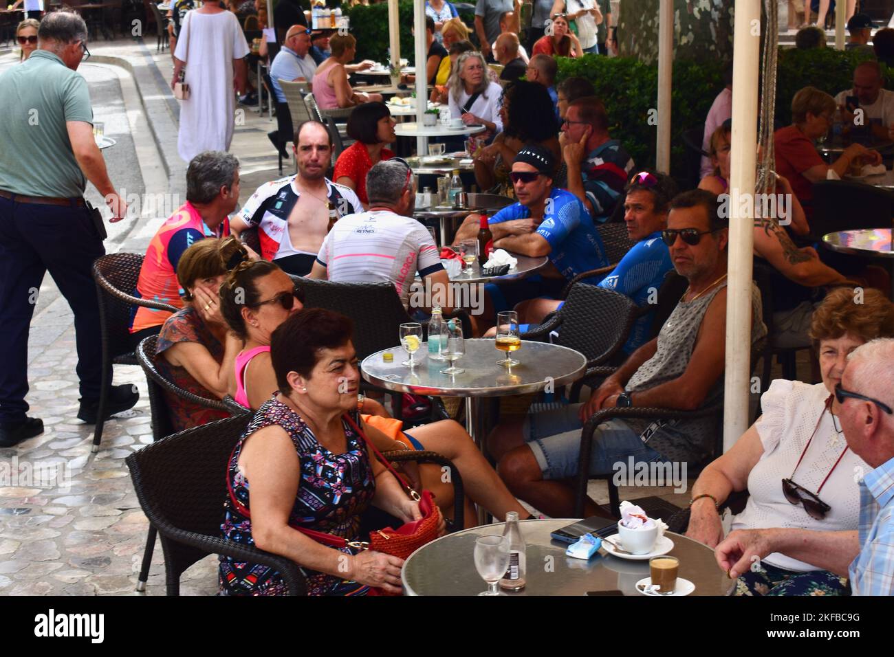 La gente si siede in uno dei tanti bar e caffetterie popolari che costeggiano le strade della città collinare di Sóller. Foto Stock