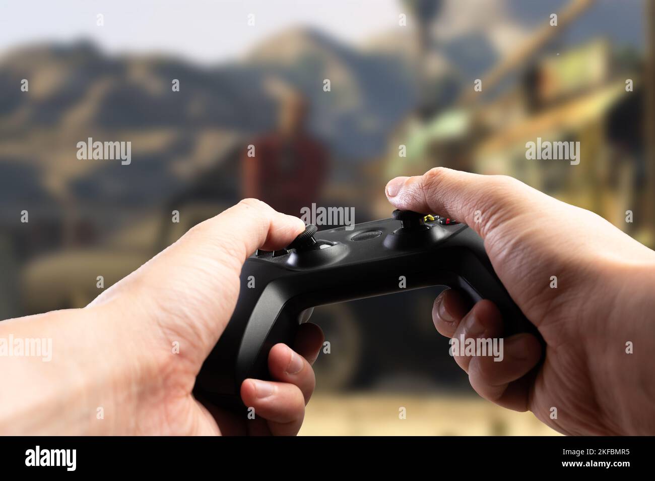 Gamepad GAM22ICB nelle mani di un giocatore sullo sfondo di un emozionante videogioco. Giochi di avventura divertente online con gli amici, passatempo divertente, moder Foto Stock