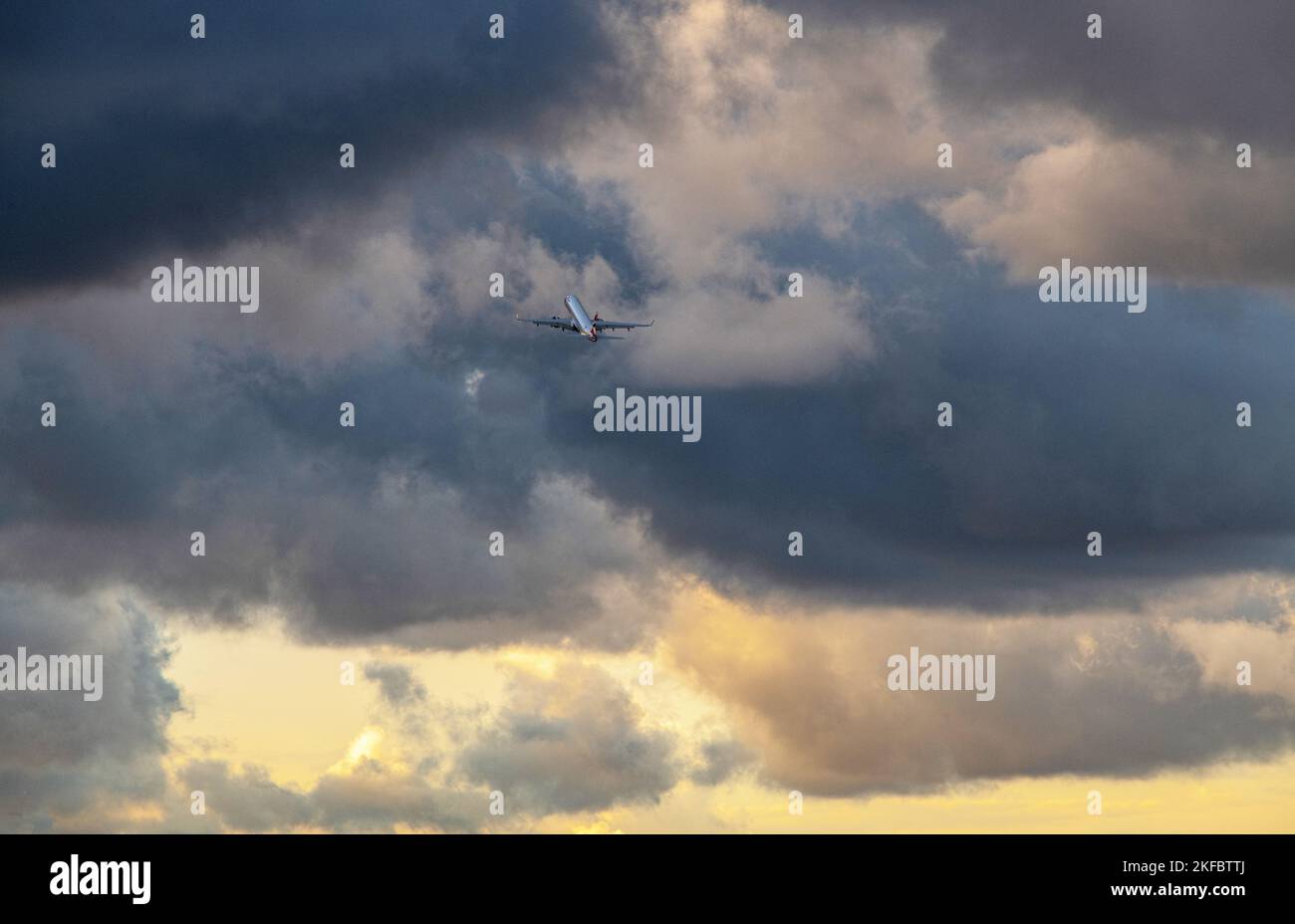 Un Embraer ERJ-190 della British Airways sale ripidamente in un cielo tempestoso dopo il decollo dall'aeroporto di London City. Foto Stock