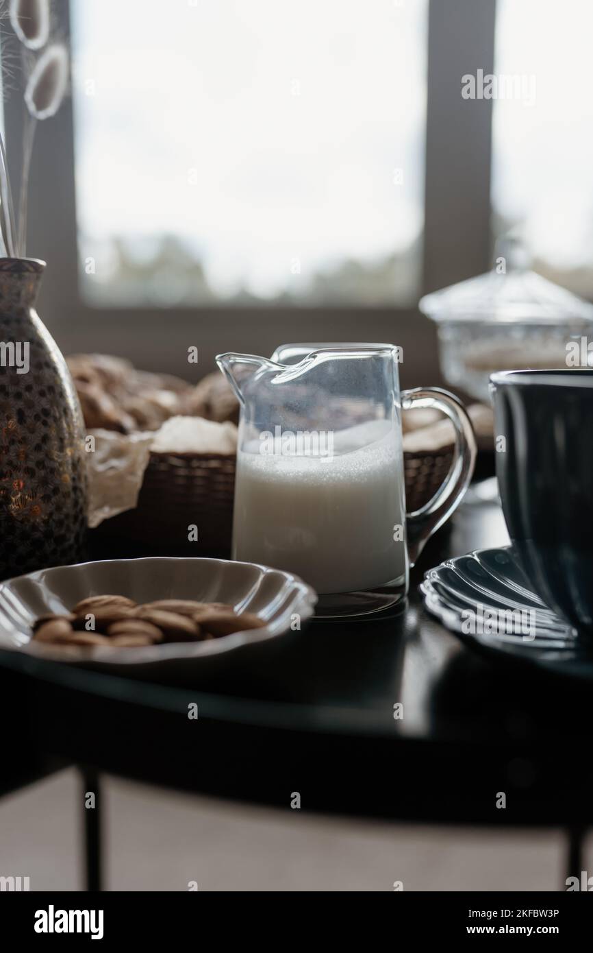 Colazione estetica. Caffè al latte, tè al latte, zucchero, mandorle, dolci alle mandorle, biscotti, marzipans e puffs. Colazione inglese in una casa accogliente. Umore autunnale. Foto Stock