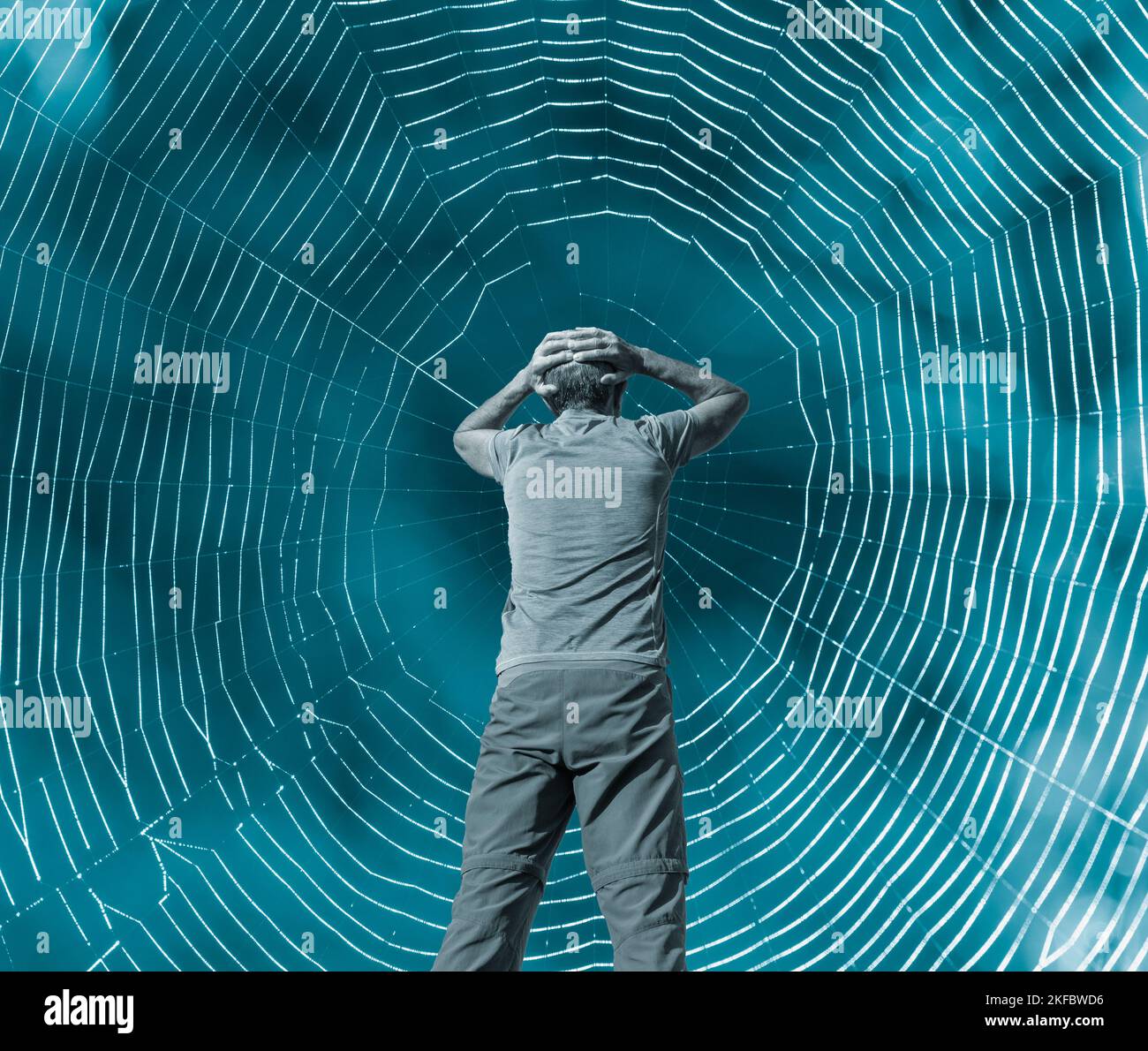 Vista posteriore dell'uomo con le mani sulla testa nella ragnatela di Spider: Depressione, stress, PTSD, intrappolato, ansia Foto Stock