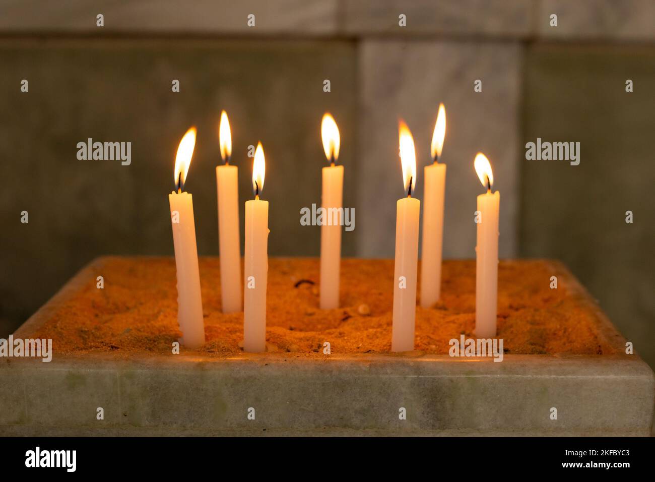 Goiânia, Goias, Brasile – 12 novembre 2022: Diverse candele accese in un porta-sabbia nella chiesa. Candele accese nel tempio, fuoco santo. Foto Stock