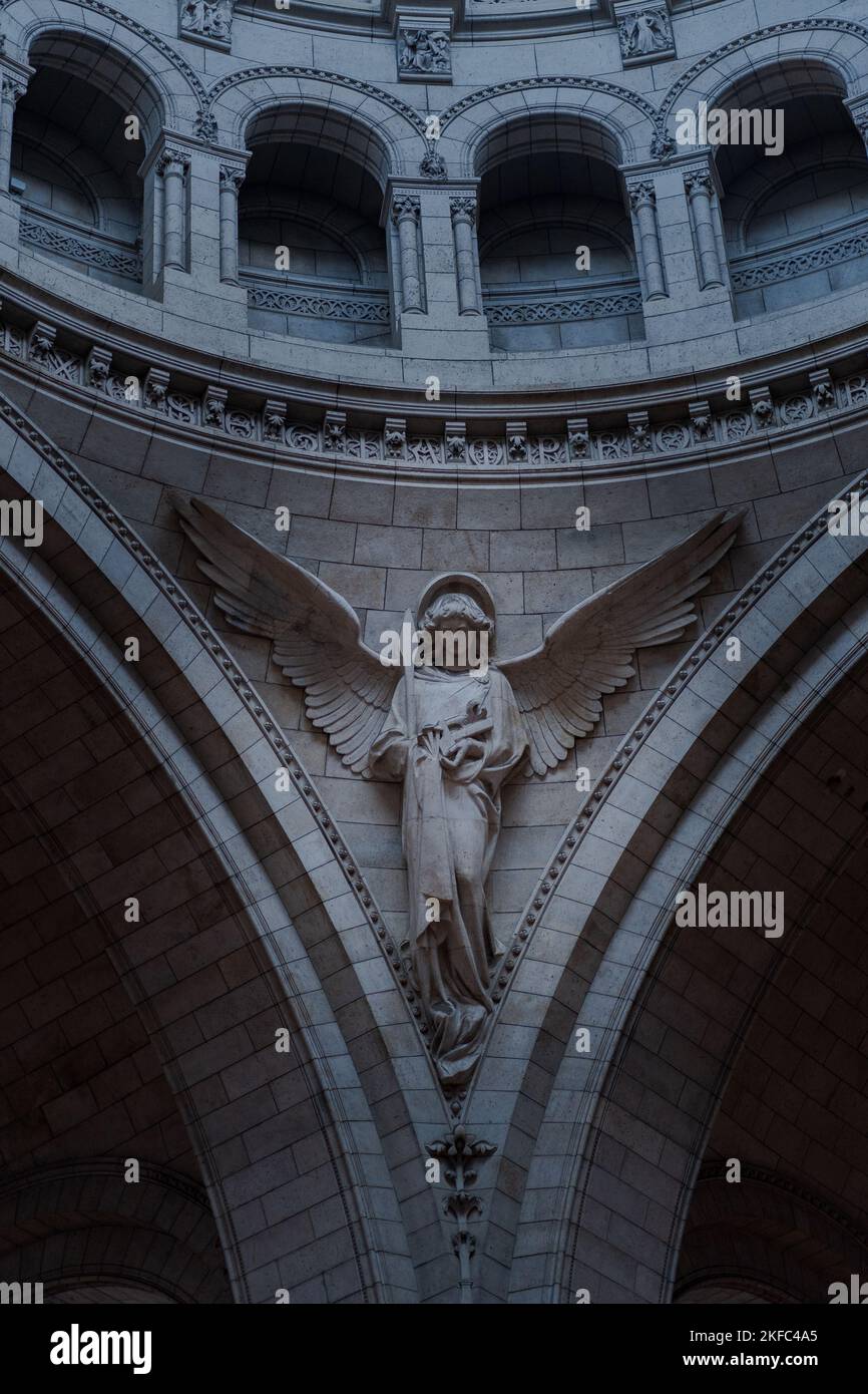 Uno scatto verticale di una bella statua d'angelo sulla parete all'interno della basilica di Santa Clotilde a Parigi Foto Stock