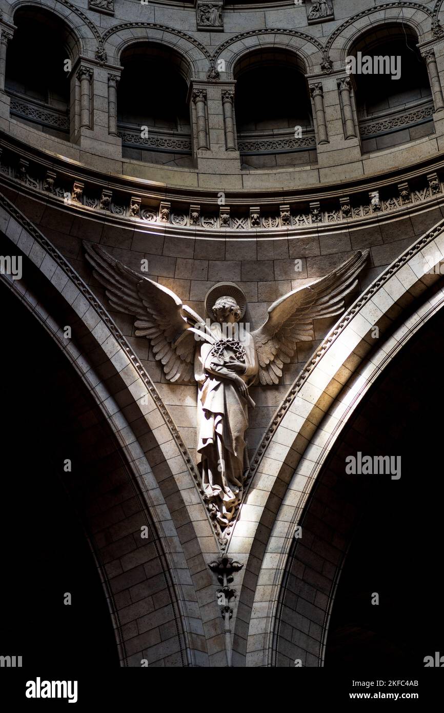 Uno scatto verticale di una bella statua d'angelo sulla parete all'interno della basilica di Santa Clotilde a Parigi Foto Stock