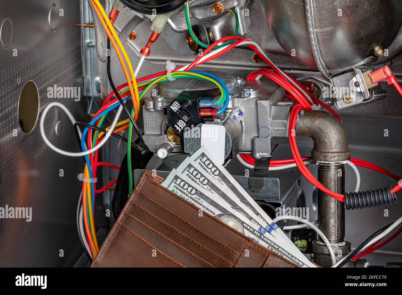 Valvola del gas del forno e portafoglio con denaro contante. Concetto di manutenzione, riparazione, assistenza e installazione HVAC. Foto Stock