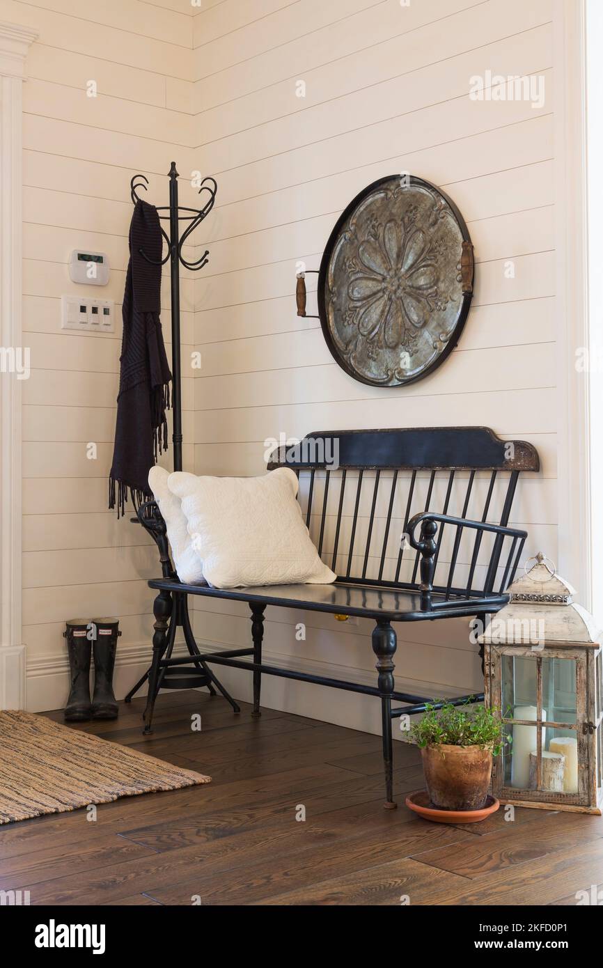 Antica panca da salotto in legno di pino e decorazioni all'ingresso con pavimenti in legno di larice colorato all'interno di una casa in stile country. Foto Stock