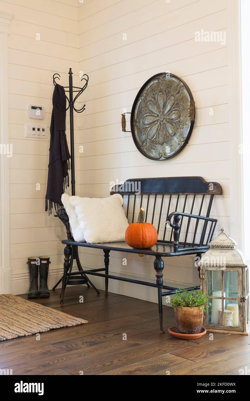 Antica panca da salotto in legno di pino e decorazioni all'ingresso con pavimenti in legno di larice colorato all'interno di una casa in stile country. Foto Stock