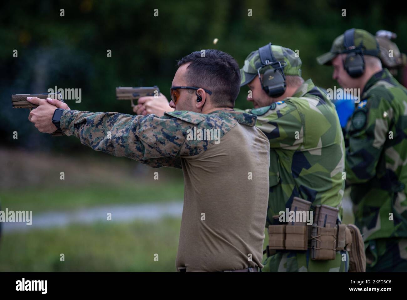 I marines statunitensi e svedesi partecipano a una qualifica di pistola durante l'esercitazione Archipelago Endeavor 22 presso la base navale di Berga, Svezia, 8 settembre 2022. AE22 è un esercizio integrato di formazione sul campo che aumenta le capacità operative e migliora la cooperazione strategica tra i Marines statunitensi e le forze svedesi. Foto Stock