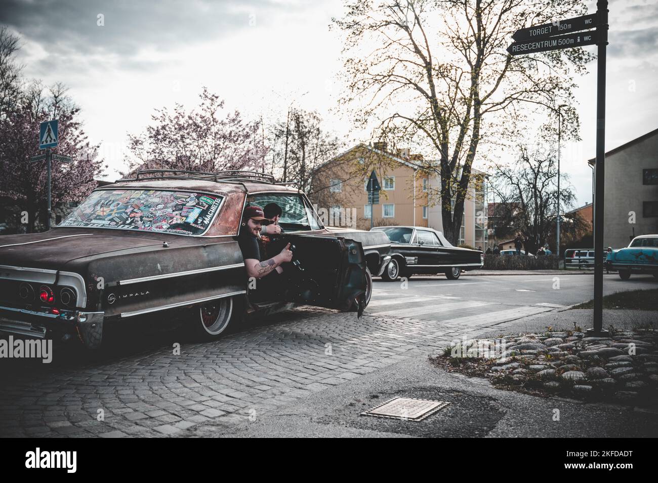 Un passeggero che decolga da una vecchia auto in strada durante l'evento Reggae Foto Stock