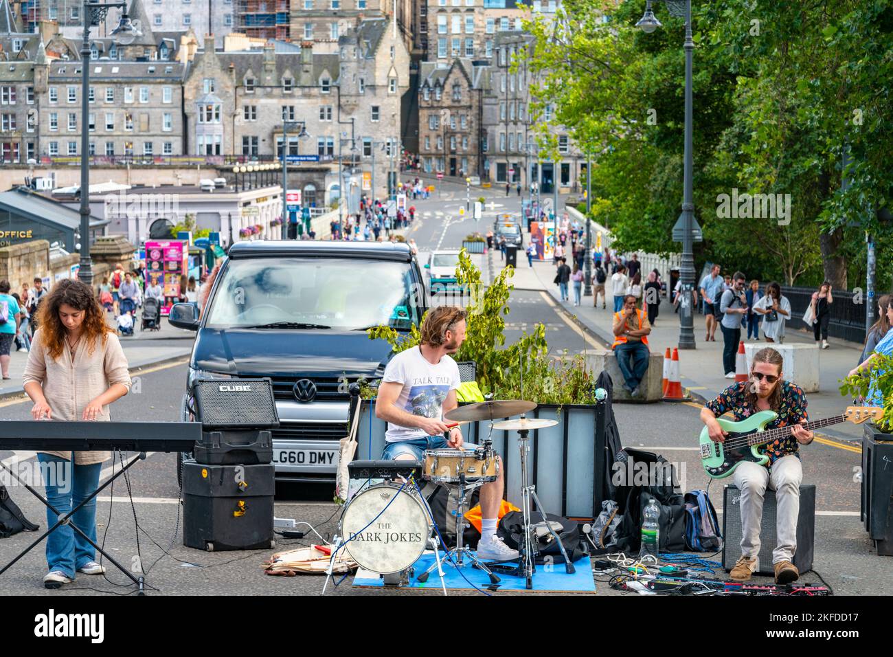 Edimburgo, Scozia-Luglio 30 2022: Il gruppo Dark Jokes, gioca nel mezzo della strada principale runnin passato la stazione ferroviaria, temporaneamente chiuso durante il P. Foto Stock