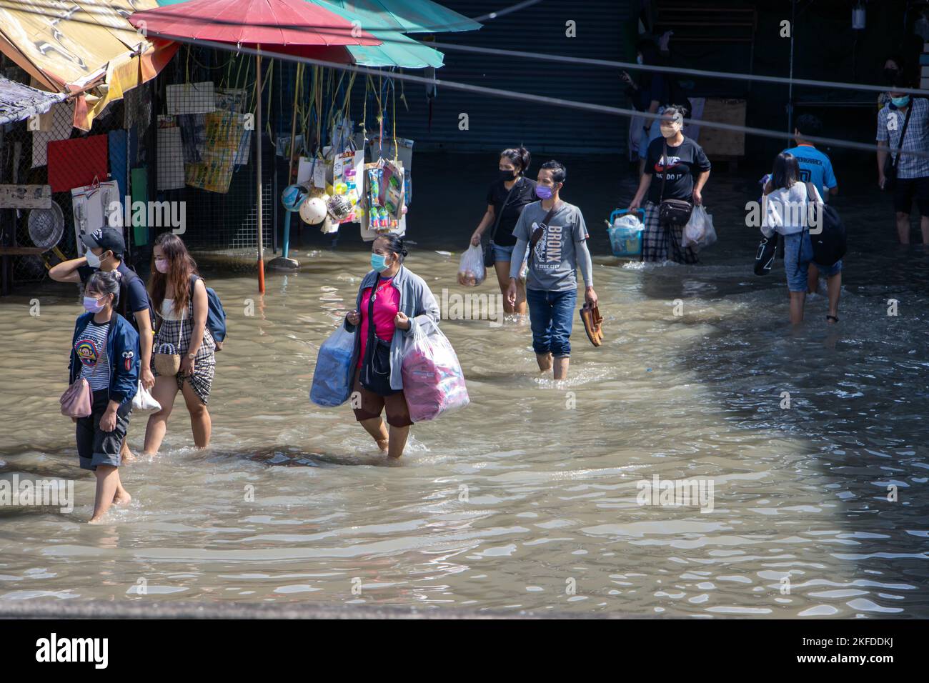 SAMUT PRAKAN, THAILANDIA, 29 2022 ottobre, le persone con l'acquisto sono a piedi attraverso la strada allagata Foto Stock