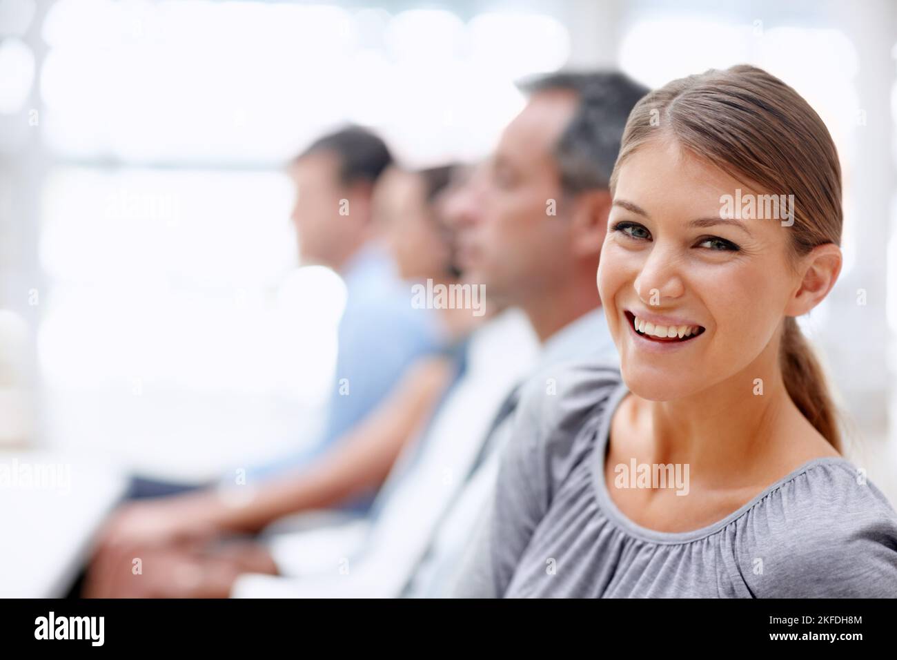 L'amore per l'apprendimento - Convenzioni aziendali. Giovane donna d'affari guarda con un sorriso mentre partecipa a un incontro. Foto Stock