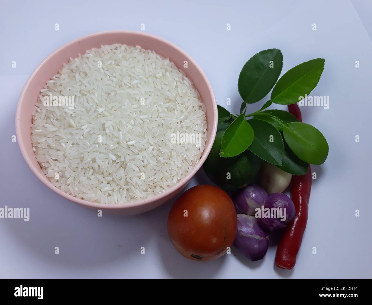 Primo piano isolato su erbe bianche, spezie aglio, cipolla, peperoncino, foglia di lime e pomodoro su recipiente rosa. Ingrediente condimento per cibo di cottura Foto Stock Primo piano isolato su erbe bianche, spezie aglio, cipolla, peperoncino, foglia di lime e pomodoro su recipiente rosa. Ingrediente condimento per cibo di cottura Foto Stock