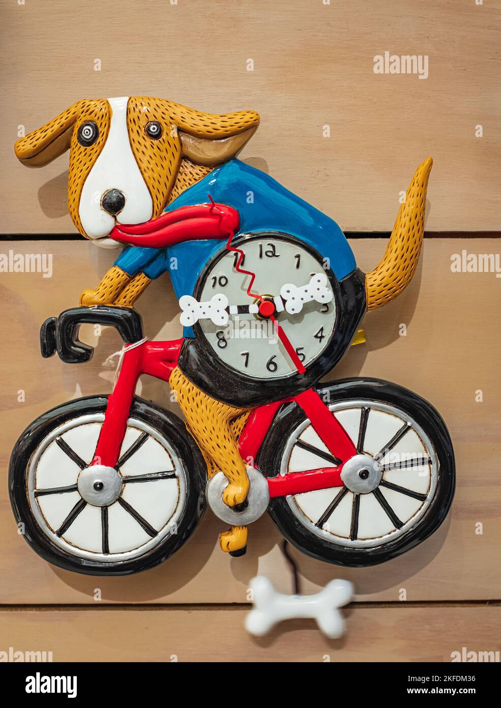 Orologio carino sul muro a forma di cane in bicicletta. Fugurine giocattolo per bambini. Allen disegni orologio da cane bicicletta-novembre 7,2022-Surrey BC Cana Foto Stock
