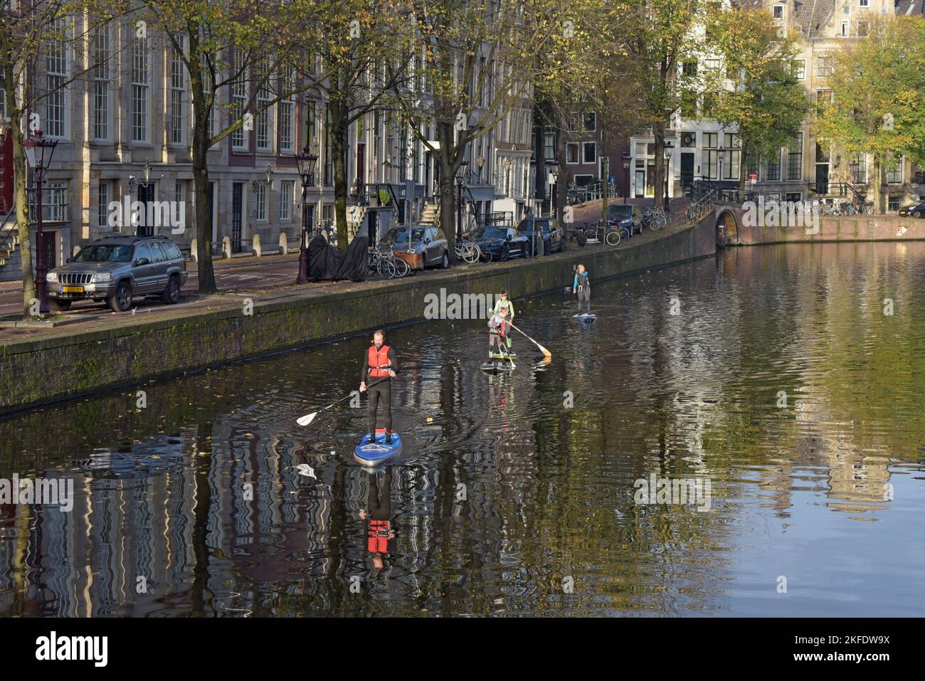 Persone paddle boarding su un canale ad Amsterdam, Paesi Bassi Foto Stock