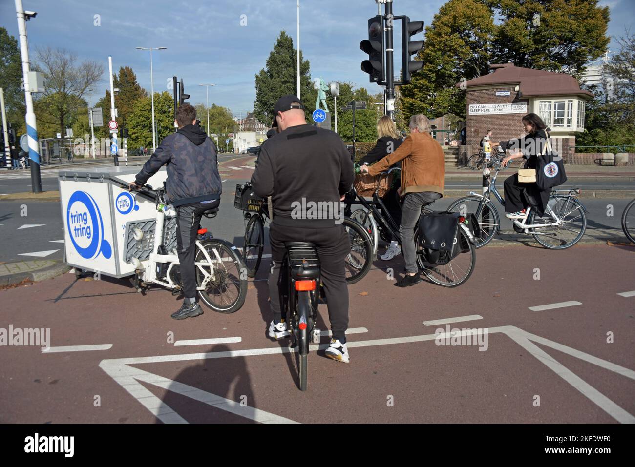 Persone in bicicletta in attesa di attraversare un incrocio stradale ad Amsterdam, Paesi Bassi Foto Stock