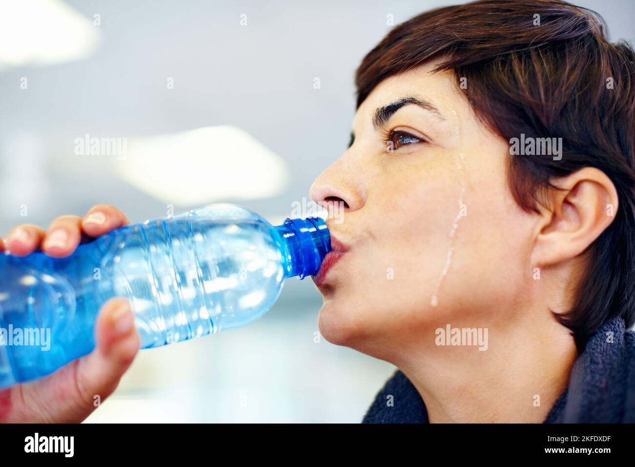 Donna idratante dopo l'esercizio fisico. Primo piano di fitness donna bere acqua dopo l'allenamento. Foto Stock