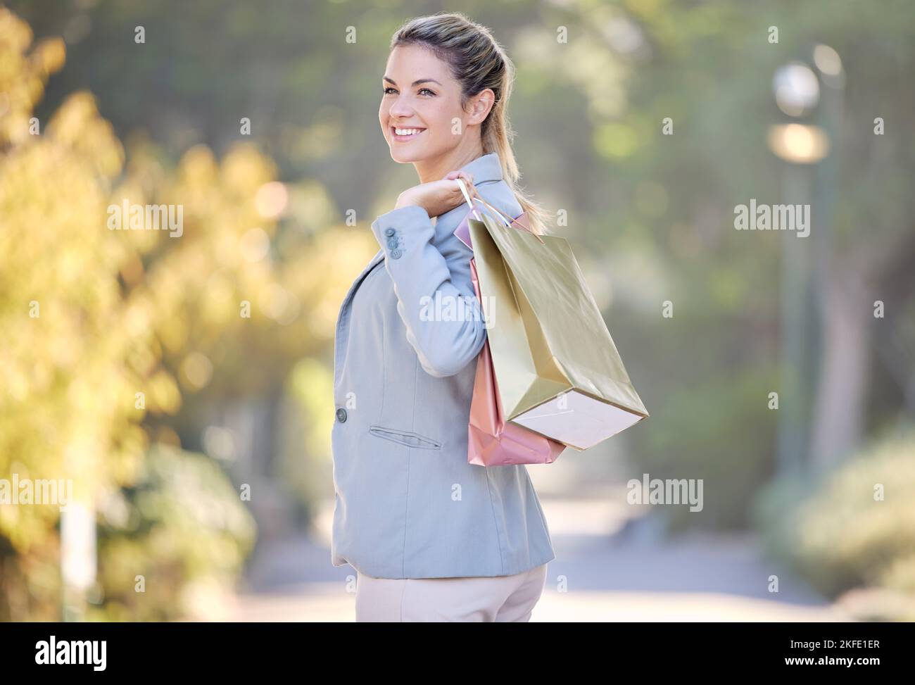 Shopping, ritratto e donna felice con le vendite al dettaglio, sconti e promozioni stock Walking in parco o all'aperto in estate. Shopping bag, regalo Foto Stock