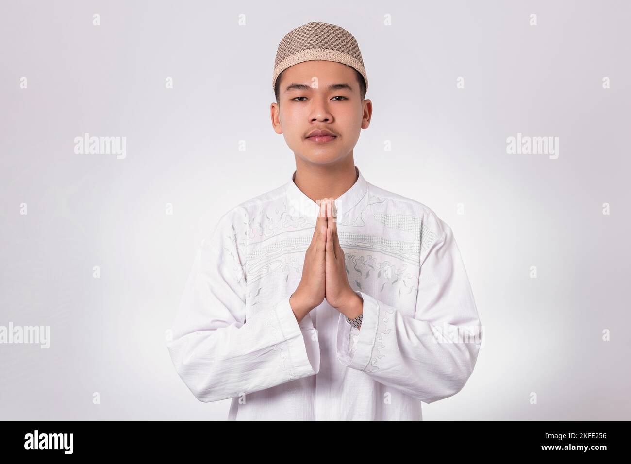 Sorridente musulmano asiatico felice celebrando Eid al-Fitr isolato sfondo bianco. Festeggia il mese Santo di Ramadhan nell'Islam Foto Stock