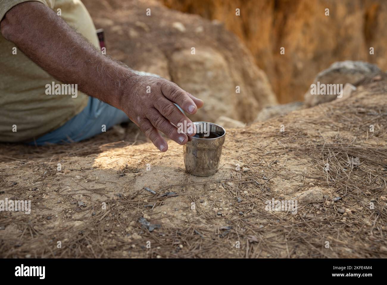 mano dell'escursionista che raggiunge per una tazza di tè Foto Stock