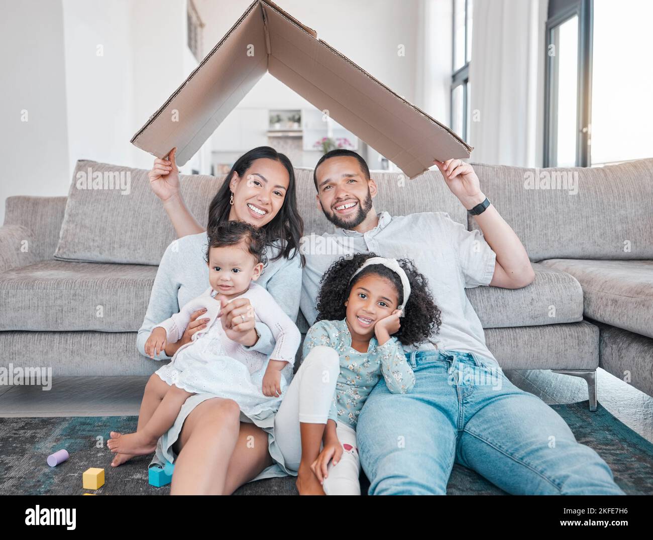 Famiglia, tetto di cartone con assicurazione casa e insieme in casa, amore in ritratto, unità con ipoteca e famiglia felice. Genitori, figli in vita Foto Stock