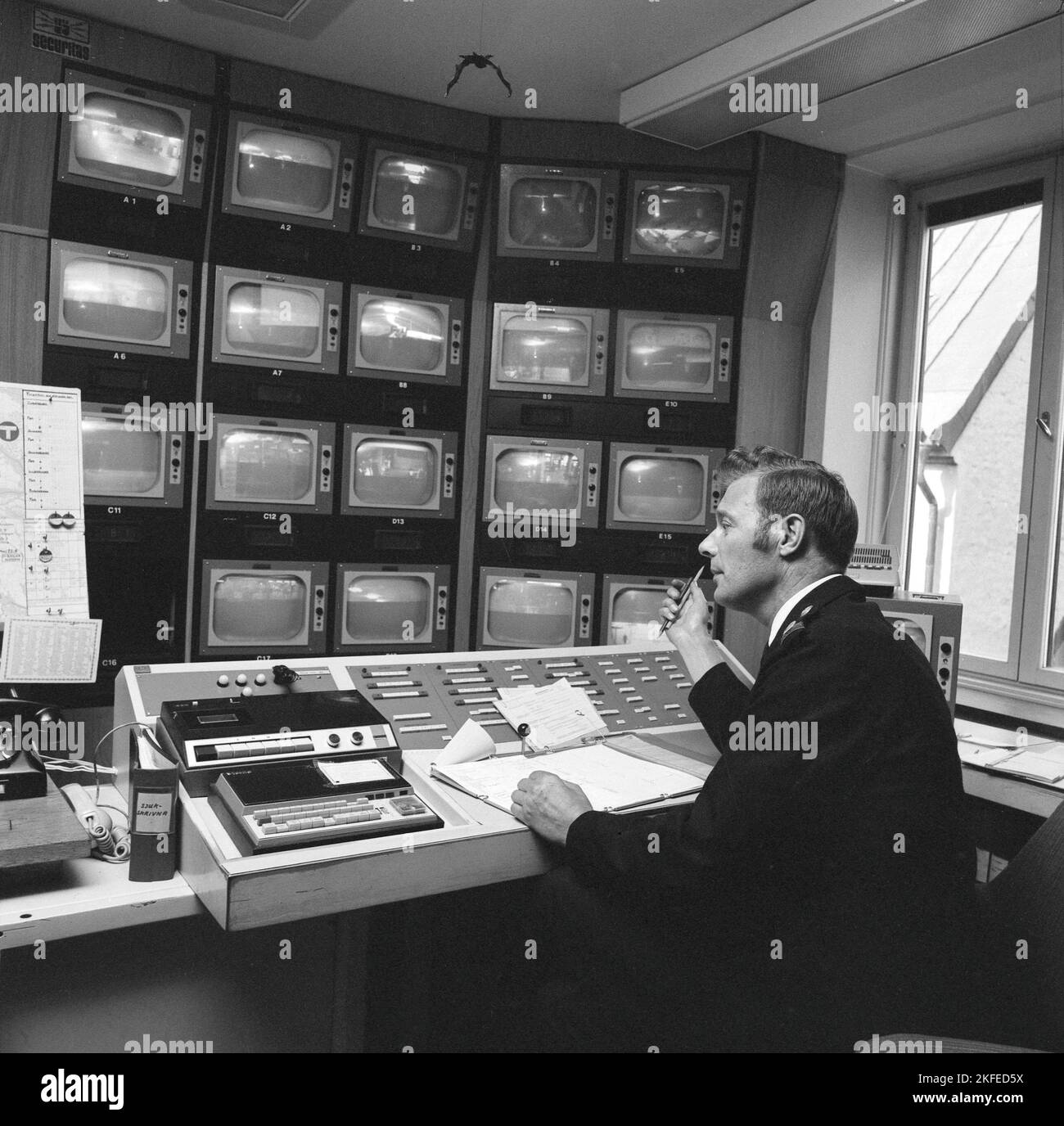 Sicurezza metropolitana nella 1970s. L'alimentazione proveniente dalle telecamere di sorveglianza della metropolitana viene monitorata. Un uomo nella sala di controllo ha molti monitor diversi di fronte a lui e il suo lavoro è quello di avvisare la sicurezza, la polizia o l'ambulanza se vede qualcosa che accade. Svezia 1970s. Kristoffersson Foto Stock