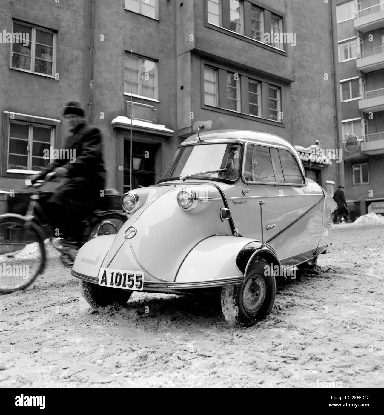 Guida invernale negli anni '1950s. Un giovane è alla guida della microcar tedesca Messerschmitt KR200. Una piccola auto a tre ruote con spazio sufficiente per ospitare due adulti e un bambino in auto. La vettura è stata fabbricata tra il 1955 e il 1964. Svezia 1956 Foto Stock