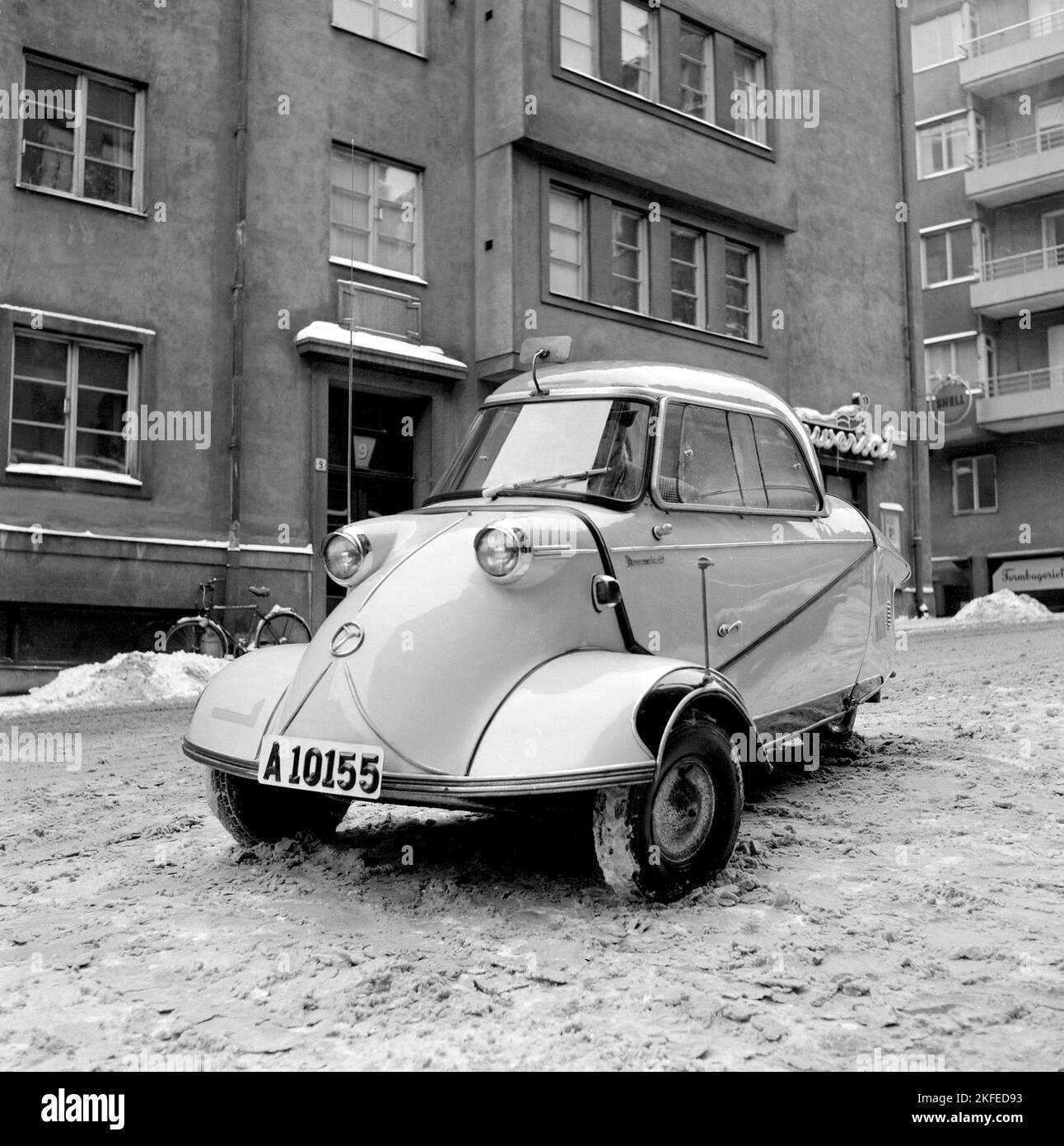 Guida invernale negli anni '1950s. Un giovane è alla guida della microcar tedesca Messerschmitt KR200. Una piccola auto a tre ruote con spazio sufficiente per ospitare due adulti e un bambino in auto. La vettura è stata fabbricata tra il 1955 e il 1964. Svezia 1956 Foto Stock