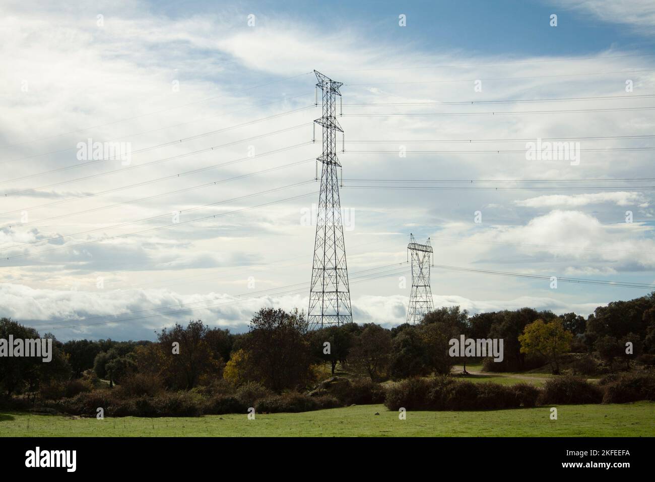 Torre elettrica ad alta tensione posta lungo il campo fino a quando i suoi cavi raggiungono la città dove trasporta la sua energia Foto Stock