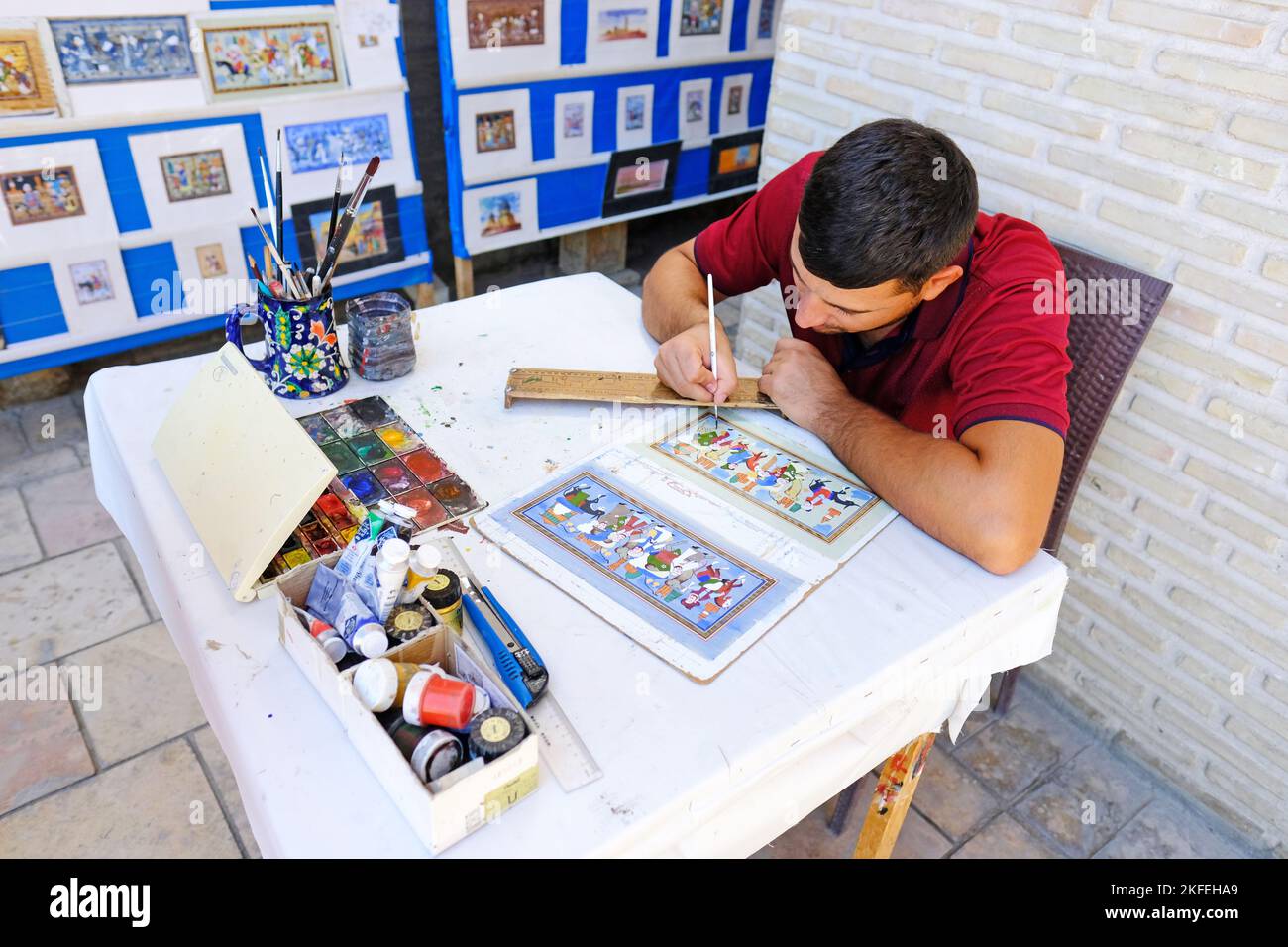 Bukhara Uzbekistan - artista locale dipingere a mano belle immagini d'arte di antichi personaggi della Via della Seta come souvenir turistici Foto Stock