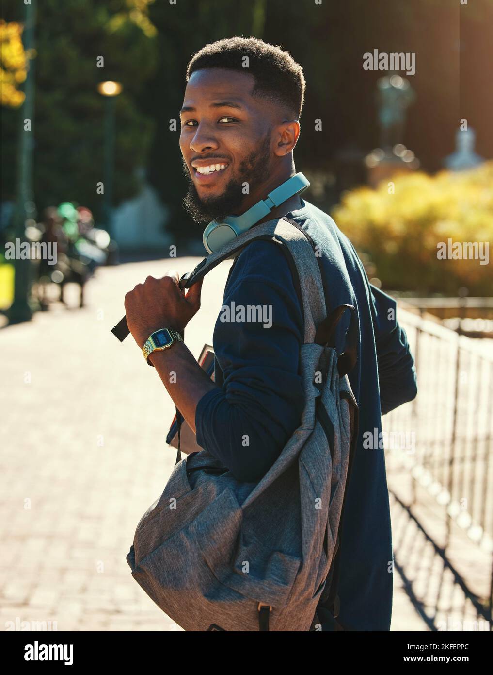 Uomo nero, studente in campus per l'università in esterni ritratto, istruzione e studio con zaino. College, sorriso e istruzione superiore con l'apprendimento Foto Stock