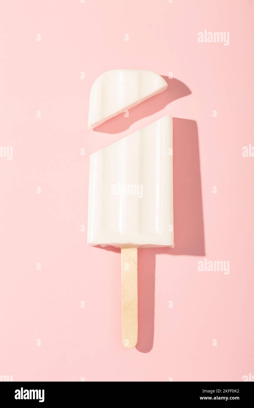 Gelato alla vaniglia su un bastone su uno sfondo rosa. Illustrazione vettoriale. Foto di alta qualità Foto Stock