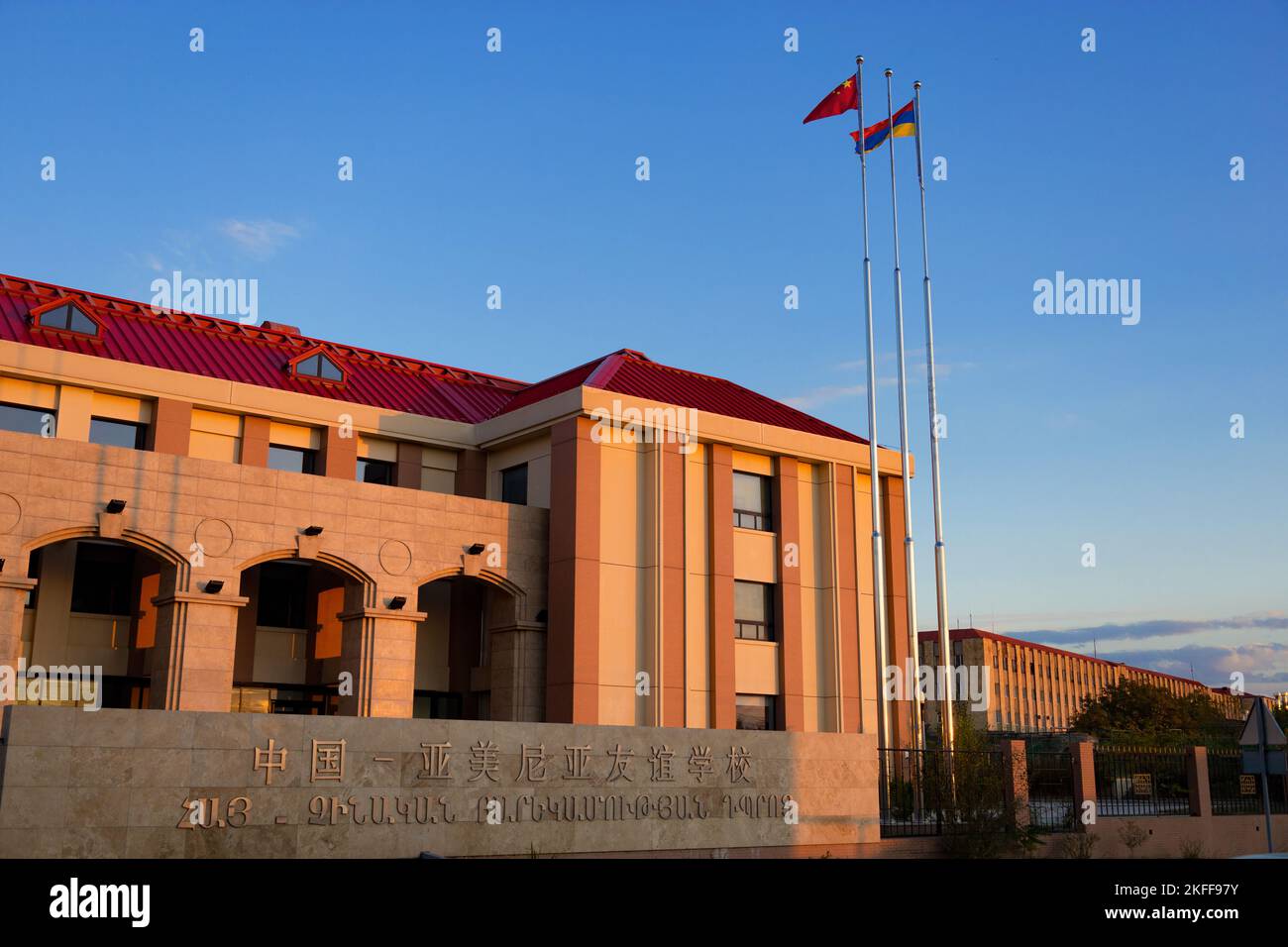 Yerevan, Armenia - 27 ottobre 2022: Edificio della scuola di amicizia armeno-cinese al tramonto, con pareti dai colori caldi durante l'ora magica, ora d'oro Foto Stock
