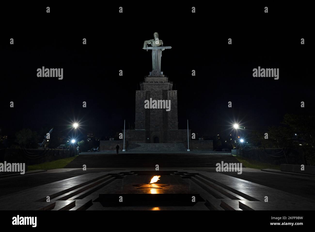 Statua di Madre Armenia nel Parco della Vittoria in serata, ripresa dal basso. Fiamma eterna con la statua di Madre Armenia sullo sfondo, in Haghtanak par Foto Stock