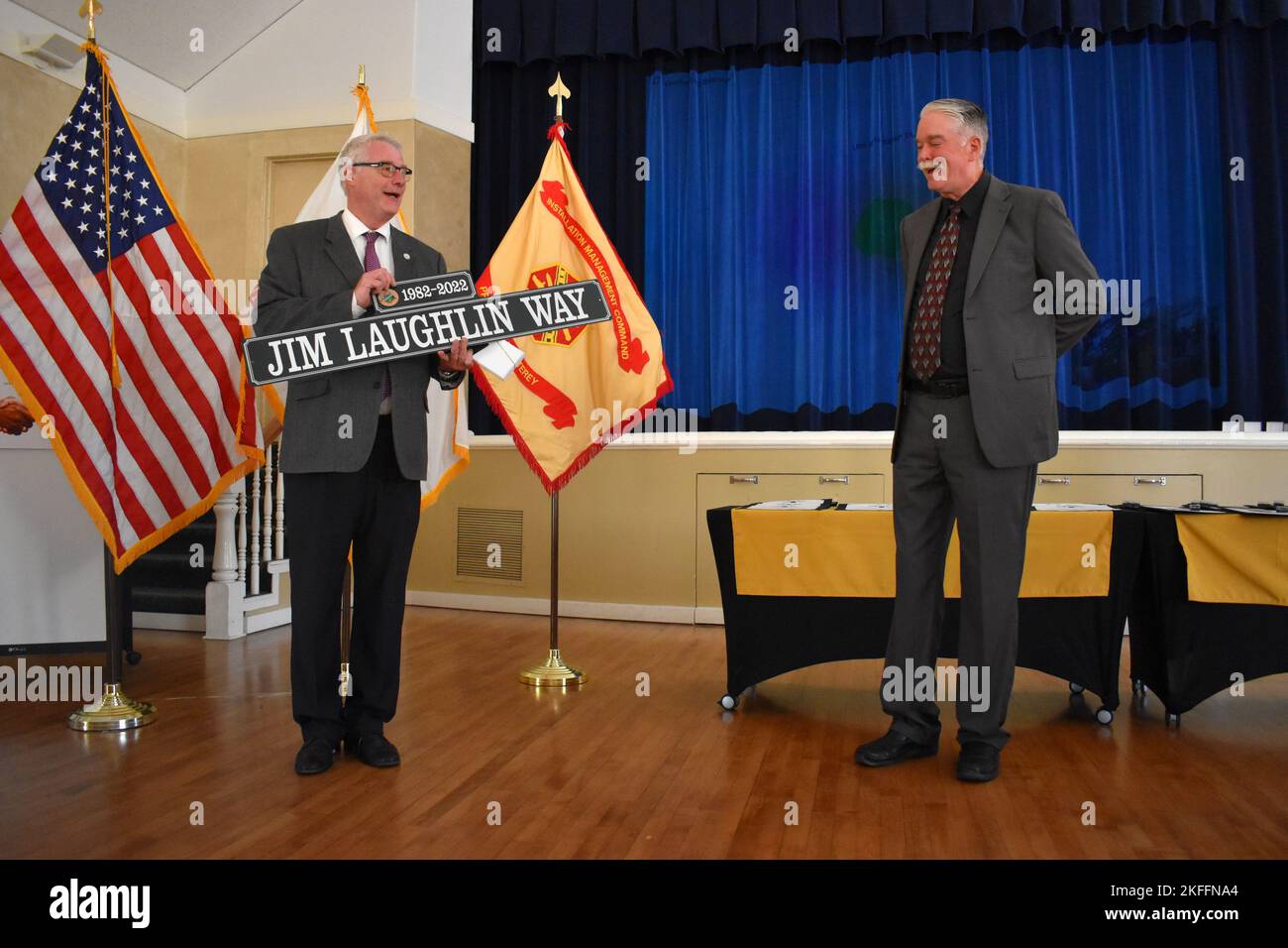 Hans Uslar, a sinistra, city manager della città di Monterey, presenta Jim Laughlin, U.S. Army Garrison Presidio di Monterey, ufficiale degli affari pubblici, con un cartello stradale originale di Monterey con il suo nome su di esso durante una cerimonia di premiazione della guarnigione al Weckerling Center, Presidio di Monterey, California, 14 settembre. Uslar ha detto che ci erano soltanto 12 di questo disegno originale rimasto, ma ha insistito che Laughlin ricevesse uno. Foto Stock