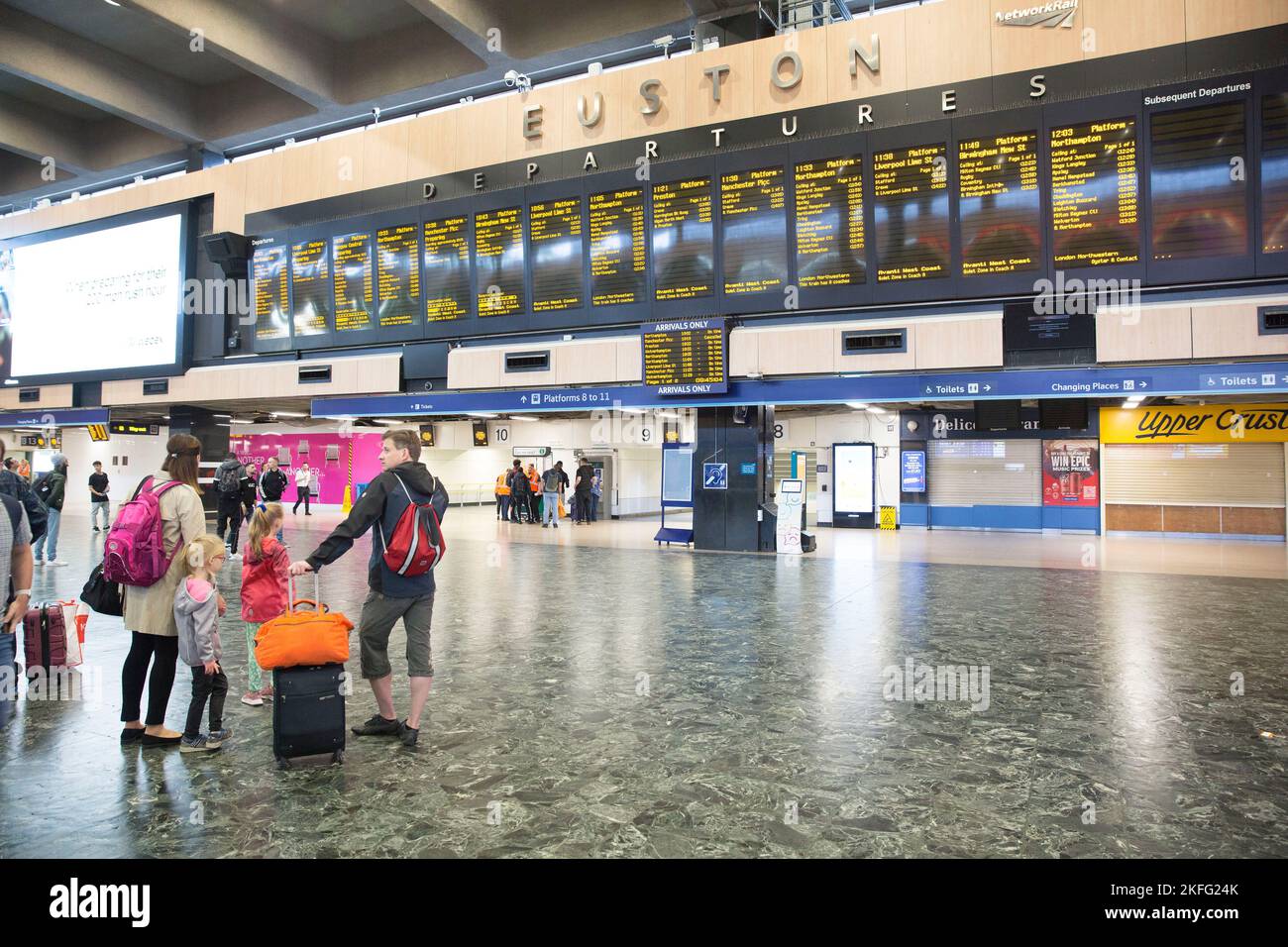 I passeggeri guardano il bordo elettrico alla stazione Euston di Londra il terzo giorno dello sciopero ferroviario. Foto Stock