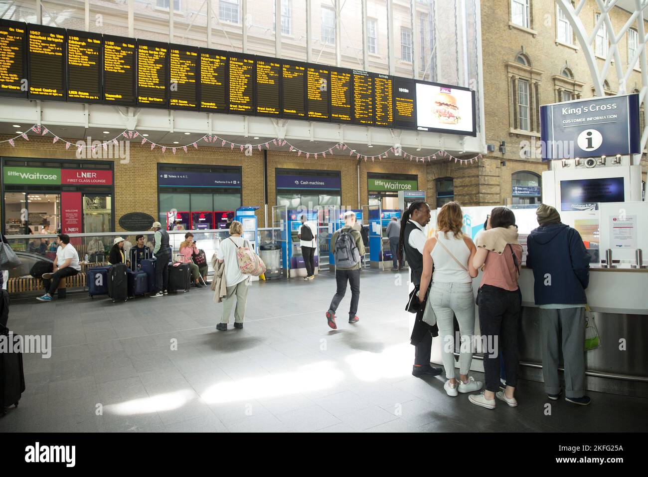 I passeggeri guardano la scheda elettrica alla King’s Cross Station di Londra il terzo giorno dello sciopero ferroviario. Foto Stock