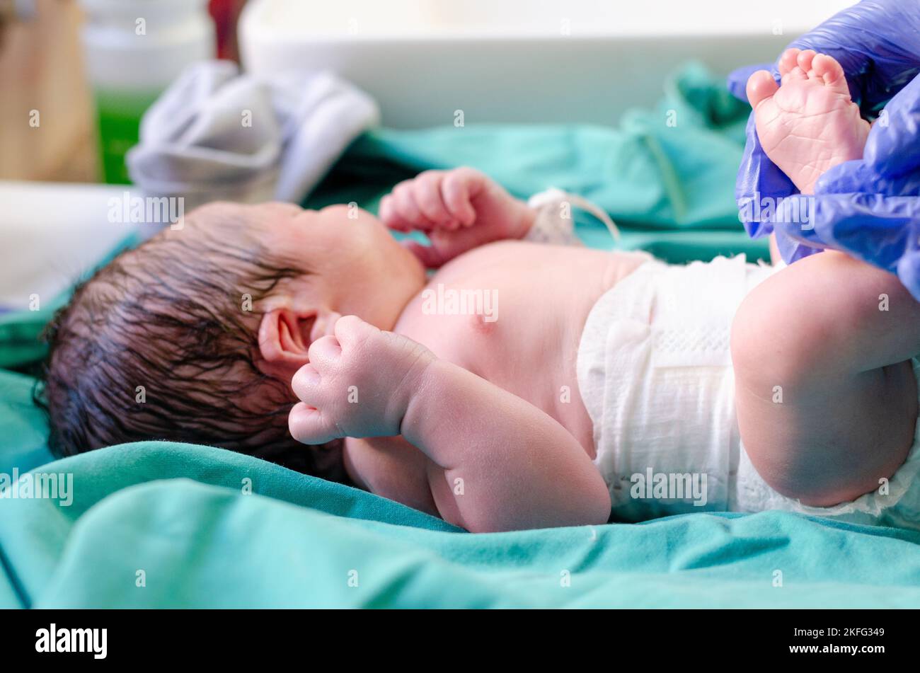 Un neonato che viene ripulito dopo la nascita. Foto Stock