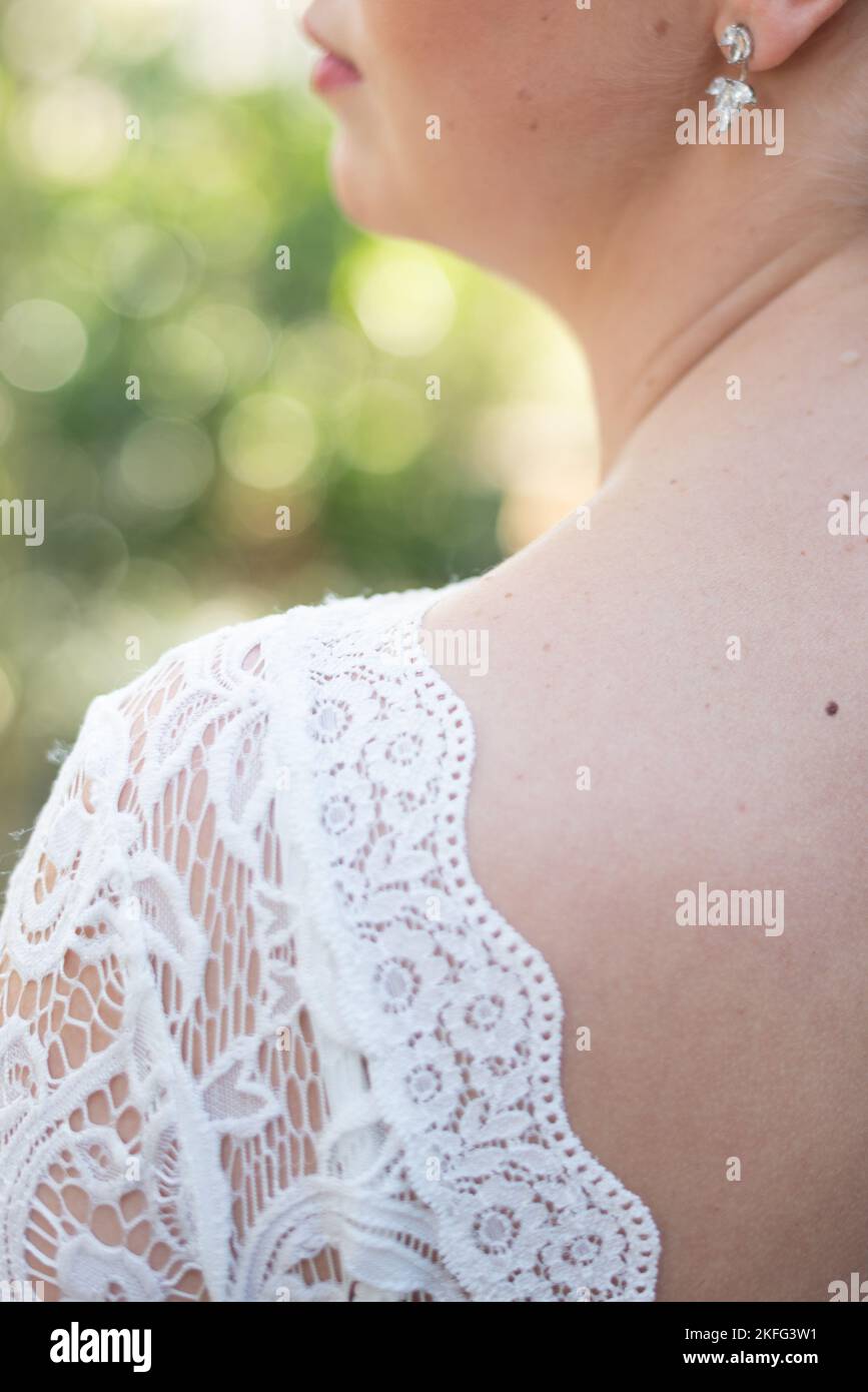 Il. retro di una sposa con il suo abito da sposa in pizzo nel suo giorno di nozze minimalistico Foto Stock