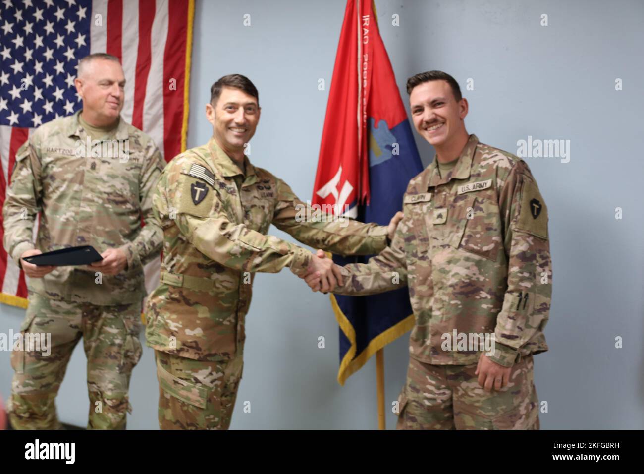 Scott P. Nicholas, comandante della Brigata dell'Aviazione di combattimento del 36th (CAB) della Guardia Nazionale dell'Esercito del Texas (al centro), accompagnato dal comando Sgt. Robert W. Hartzog, comandante sergente maggiore della cabina 36th (a sinistra), si congratula con Sgt. Daniel T. Clavin, sergente di supporto delle operazioni di segnale, 25U, assegnato alla sede centrale e alla società di quartier generale, 3-142 Battaglione dell'elicottero d'assalto della Guardia nazionale dell'esercito di New York, durante un incontro di comando e di personale tenuto presso la sede del CAB 36th a Camp Bhuering, Kuwait, 15 settembre 2022. Clavin, un nativo di Farmingville, NY, è stato presentato un CE Foto Stock