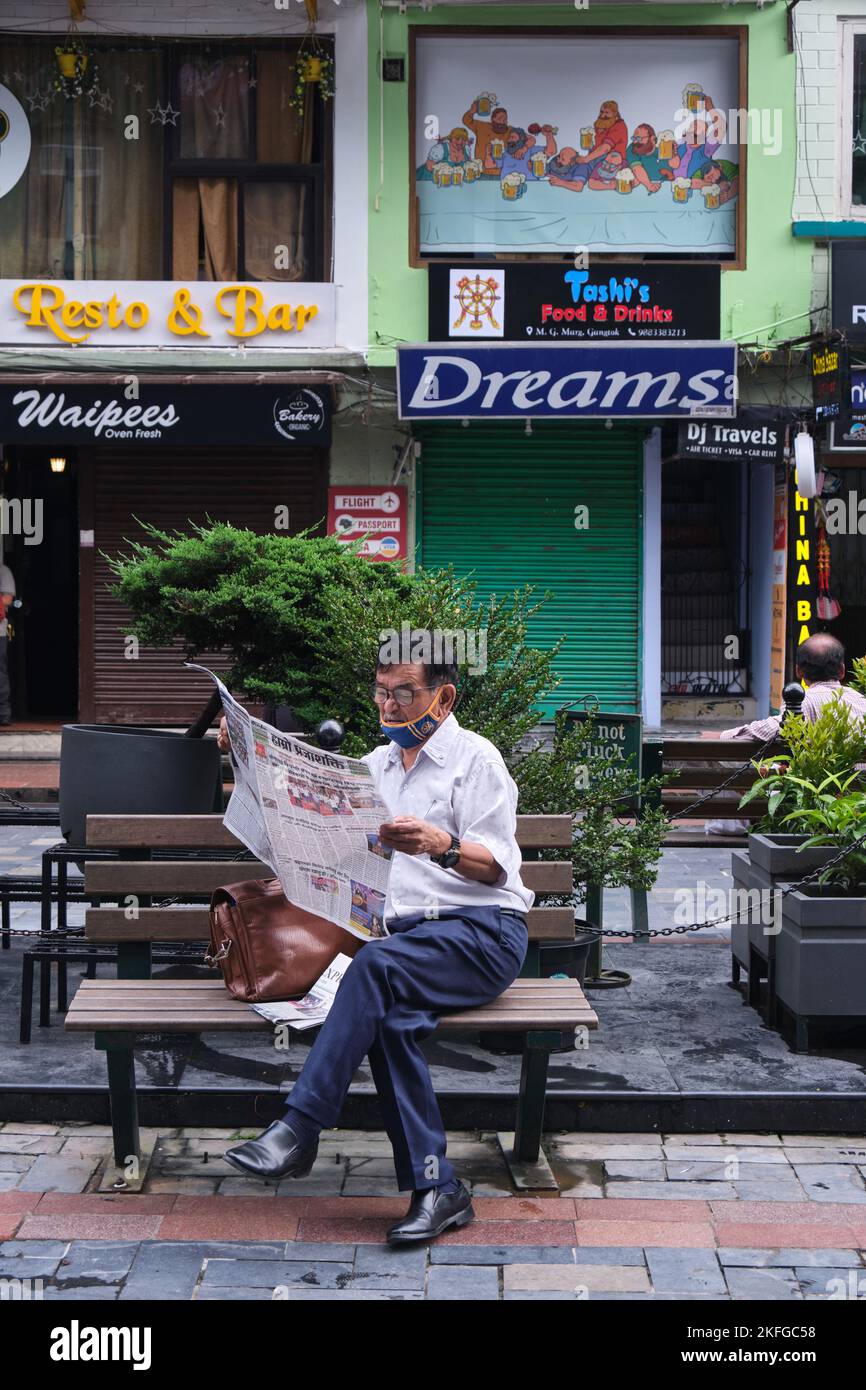Gangtok, INDIA, 21 giugno 2022, uomo di mezza età che legge il giornale sul lato della strada. Foto Stock