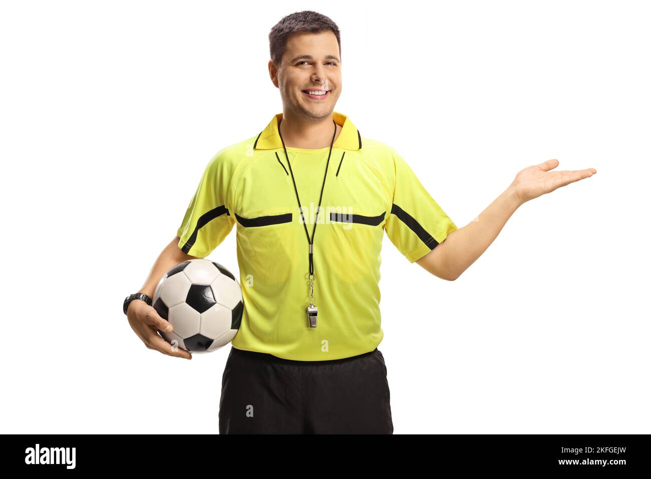 Sorridente arbitro di calcio che mostra con mano e tenendo una palla isolata su sfondo bianco Foto Stock