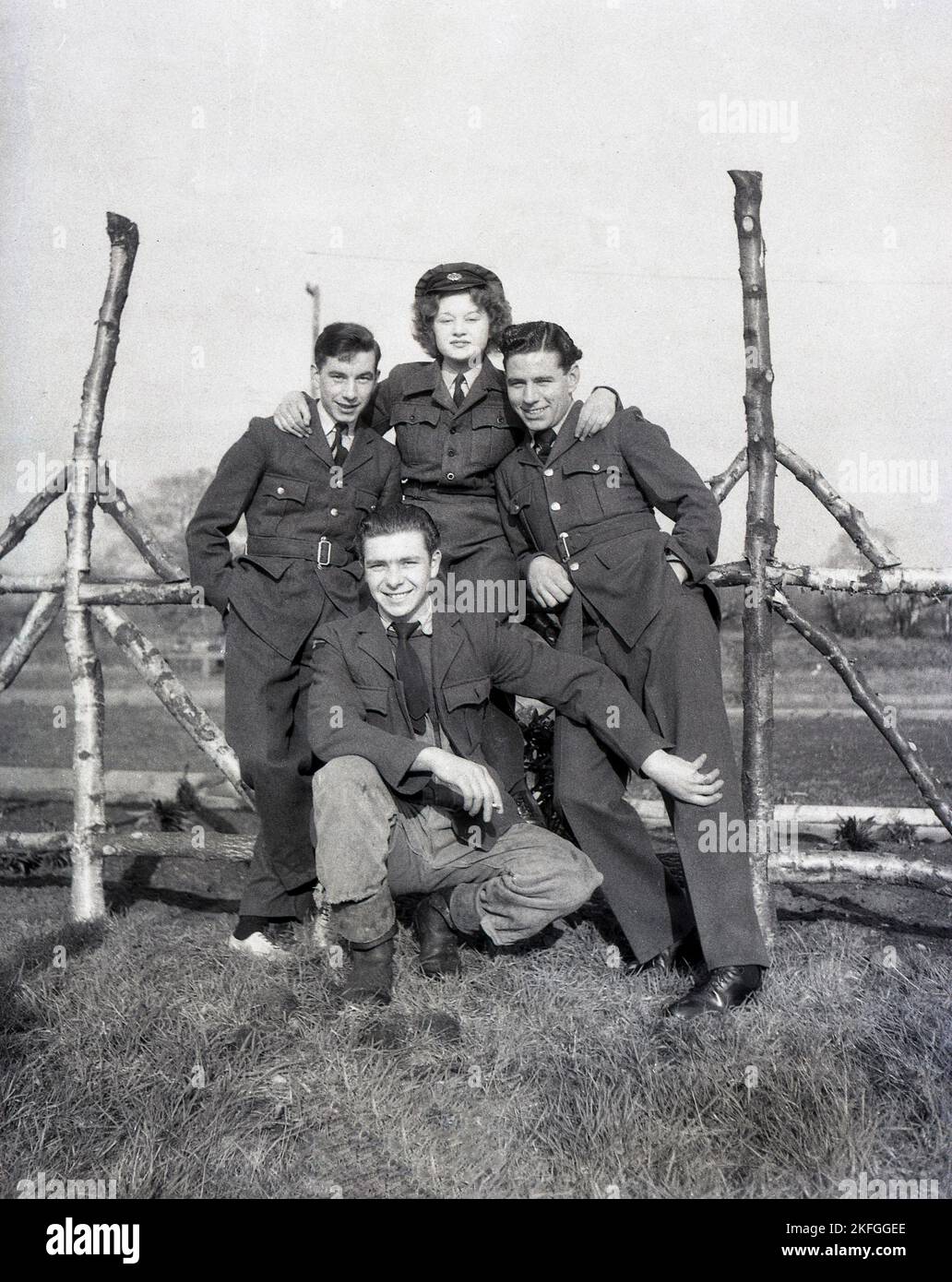 Anni '1940, in posa per una foto con tre uomini fuori Longford Camp, a RAF Tern Hill vicino a Market Drayton, Shropshire, Inghilterra, Regno Unito, una giovane donna WAAF con colletto e cravatta, tunica in tessuto di lana, pantaloni e cappello. La Women's Auxiliary Air Force (WAAF) è stata costituita nel giugno 1939, con reclute iniziali di età compresa tra i 18-43 anni. Foto Stock